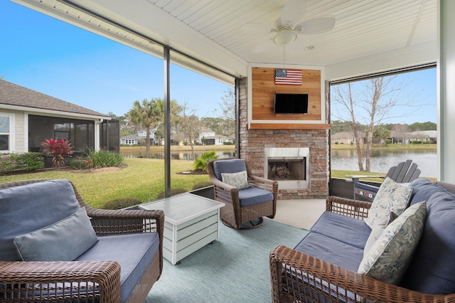 sunroom with an outdoor stone fireplace and ceiling fan