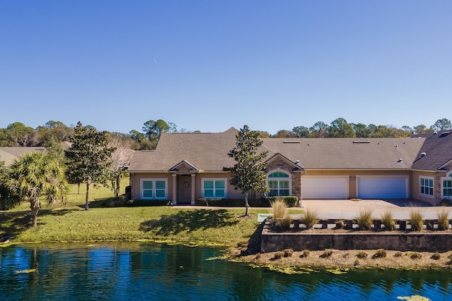 single story home with a water view, a garage, and a front lawn