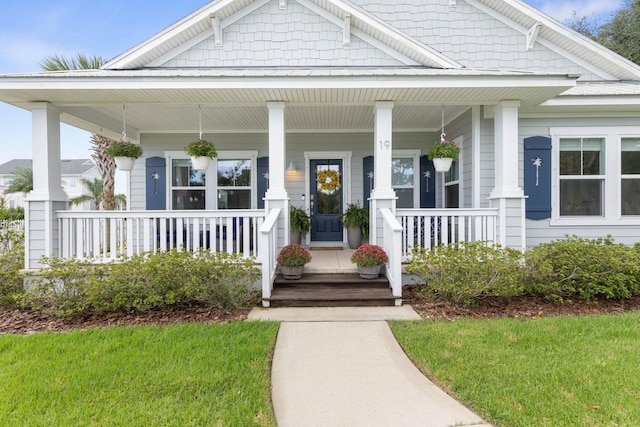 19 Smiling Fish Ln, Palm Coast, FL 32137 - view of exterior entry with covered porch and a lawn