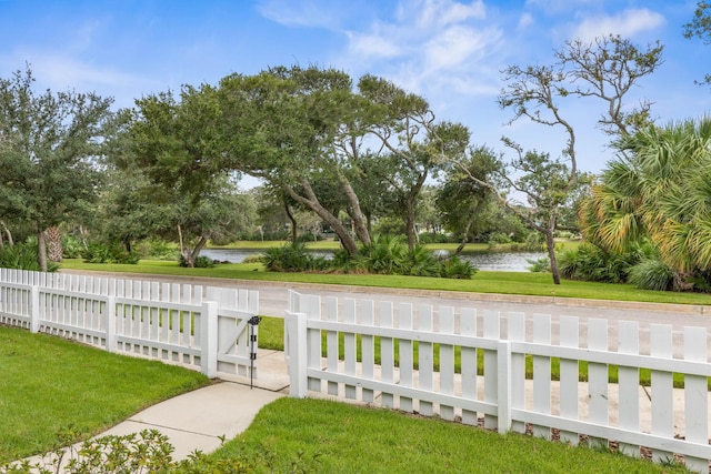 19 Smiling Fish Ln, Palm Coast, FL 32137 - fenced front yard with a water view and view of wooded area