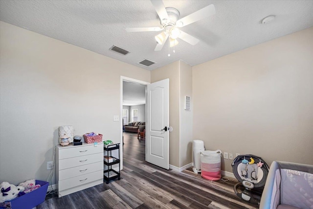 bedroom featuring a textured ceiling, ceiling fan, and dark wood-type flooring