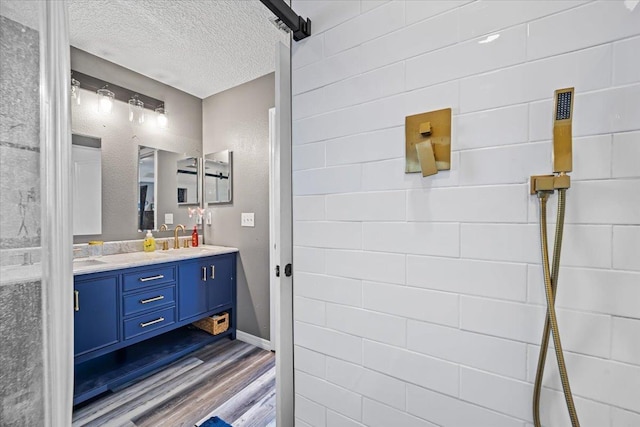 bathroom featuring hardwood / wood-style floors, vanity, and a textured ceiling