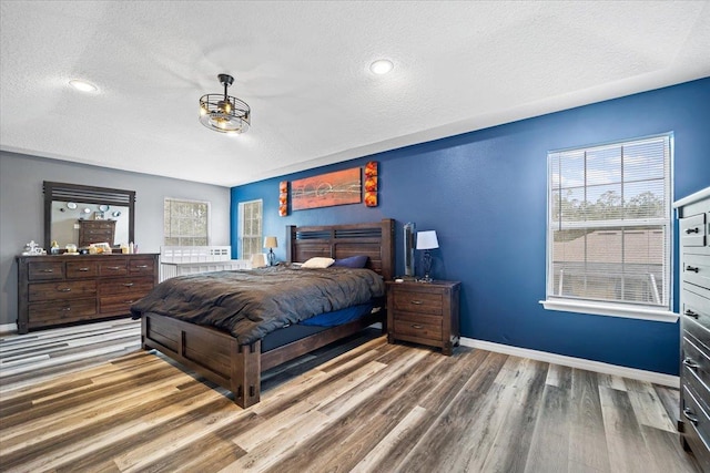 bedroom featuring wood-type flooring and a textured ceiling