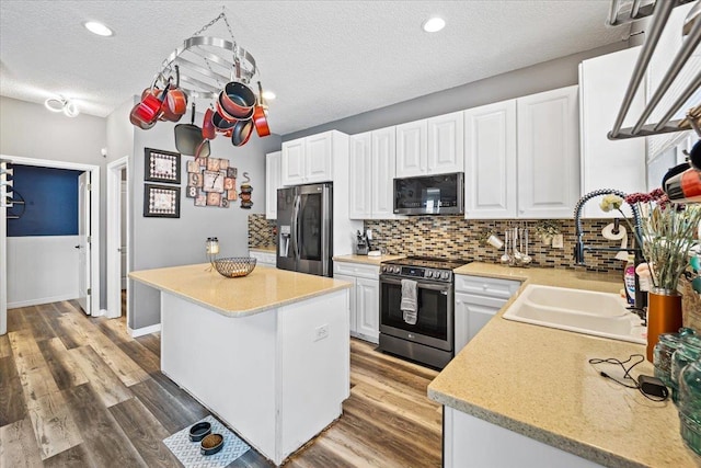 kitchen with sink, white cabinets, a textured ceiling, and appliances with stainless steel finishes