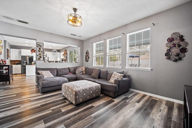 living room with a textured ceiling and dark hardwood / wood-style floors