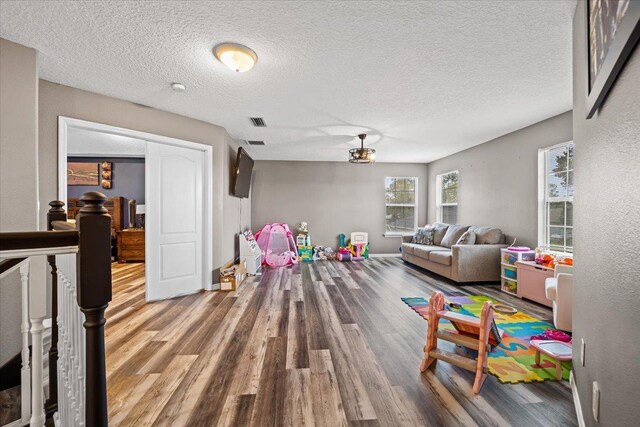 game room with hardwood / wood-style flooring and a textured ceiling