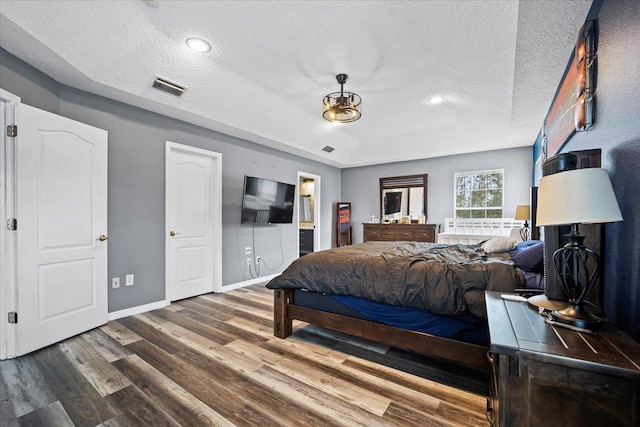 bedroom featuring hardwood / wood-style flooring and a textured ceiling