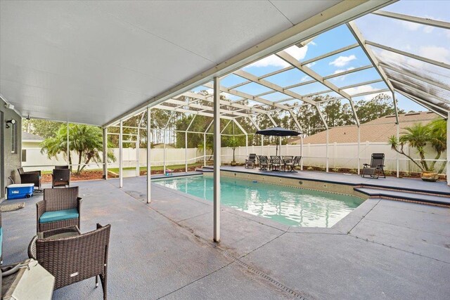 view of swimming pool featuring glass enclosure and a patio area