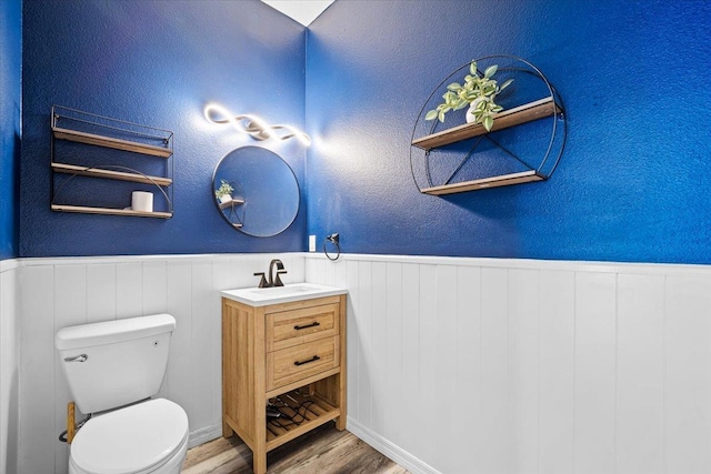 bathroom with vanity, toilet, and wood-type flooring