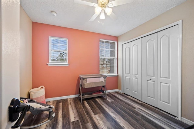 misc room featuring a textured ceiling, ceiling fan, and dark wood-type flooring