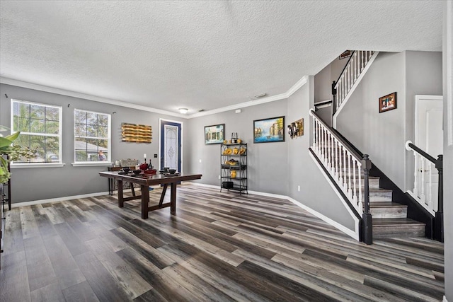 rec room featuring a textured ceiling, dark hardwood / wood-style flooring, and crown molding