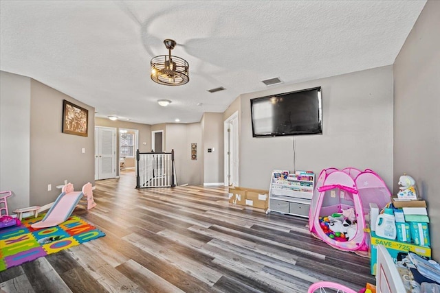 game room with hardwood / wood-style floors and a textured ceiling