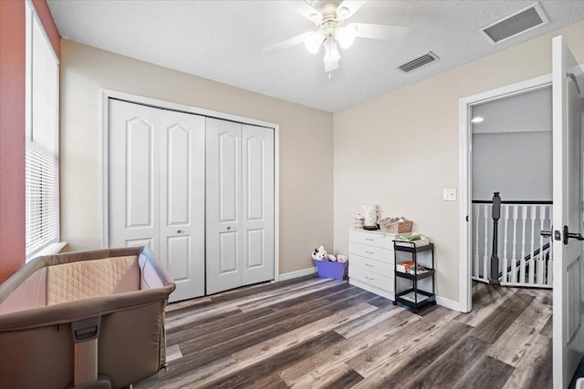 living area featuring a textured ceiling, dark hardwood / wood-style flooring, and ceiling fan