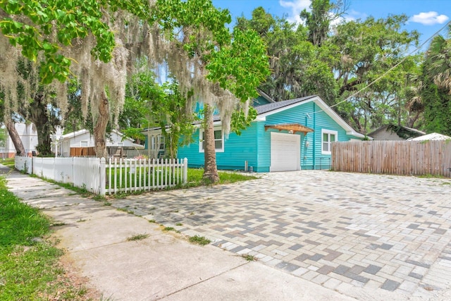 13 Douglas Ave, Saint Augustine, FL 32084 - view of front of house featuring an attached garage, a fenced front yard, and decorative driveway