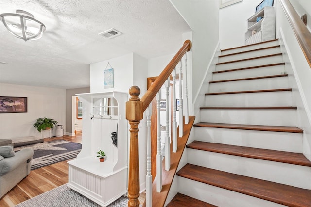 13 Douglas Ave, Saint Augustine, FL 32084 - stairs with wood finished floors, a textured ceiling, and baseboards
