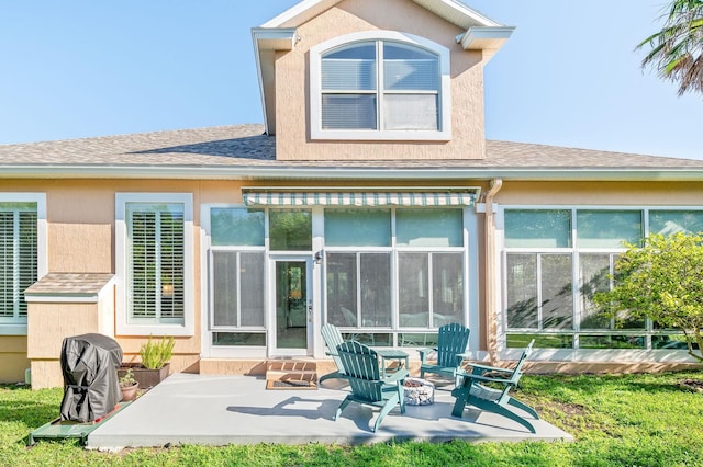 back of house with a sunroom, a shingled roof, and a patio