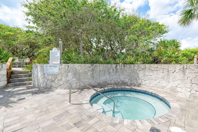 view of swimming pool featuring a hot tub