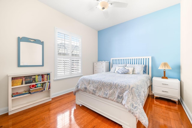 bedroom with a ceiling fan, baseboards, and wood finished floors