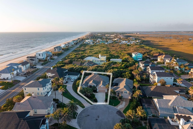 drone / aerial view featuring a residential view, a beach view, and a water view