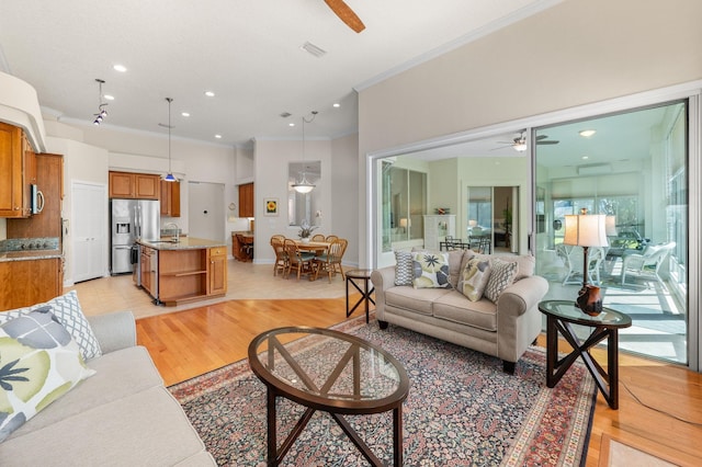living room featuring crown molding, recessed lighting, ceiling fan, and light wood-type flooring