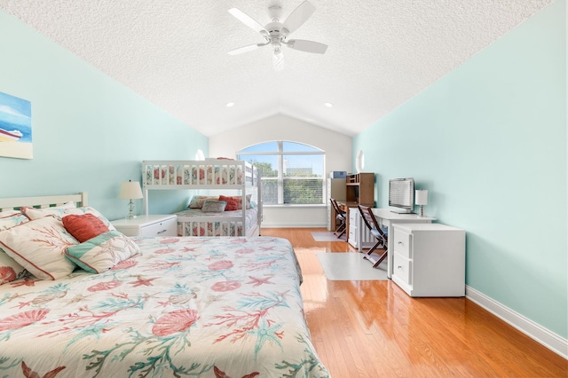 bedroom with baseboards, vaulted ceiling, light wood-type flooring, and a textured ceiling