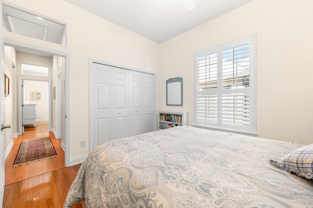 bedroom featuring baseboards, a closet, and hardwood / wood-style floors