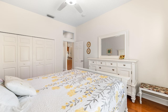 bedroom with a ceiling fan, baseboards, wood finished floors, visible vents, and a closet