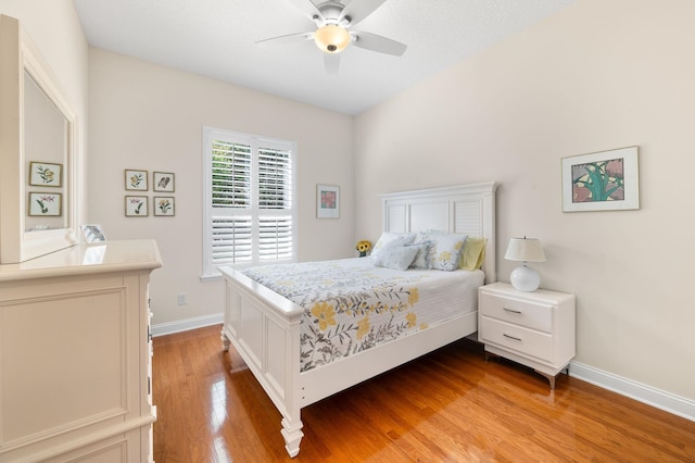 bedroom with baseboards, ceiling fan, and light wood finished floors