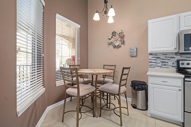 1101 Royal Troon Ln, Saint Augustine, FL 32086 - dining area featuring light tile patterned flooring, baseboards, and a chandelier