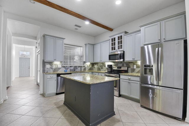 kitchen featuring beamed ceiling, backsplash, a center island, and stainless steel appliances