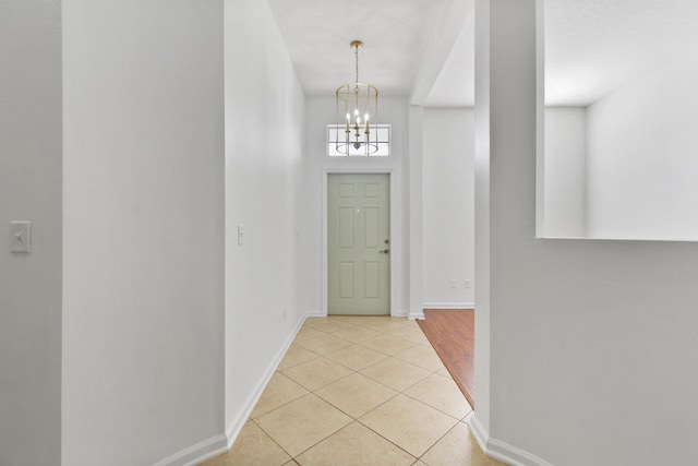 entrance foyer with light tile patterned floors and a chandelier