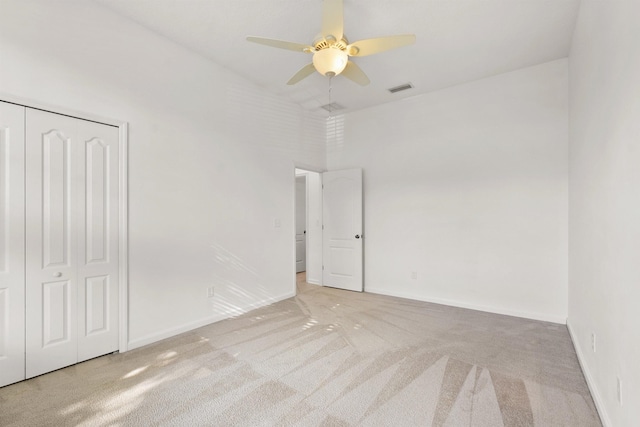 empty room featuring ceiling fan and light carpet