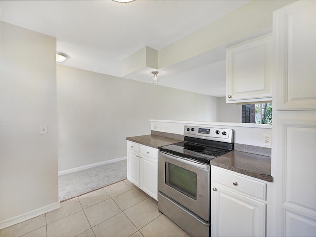 kitchen with white cabinetry, light tile patterned floors, and stainless steel range with electric stovetop