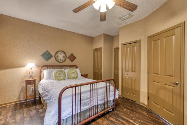 998 Aragon Ave, Saint Augustine, FL 32086 - bedroom featuring dark wood finished floors, a textured wall, a ceiling fan, baseboards, and a textured ceiling