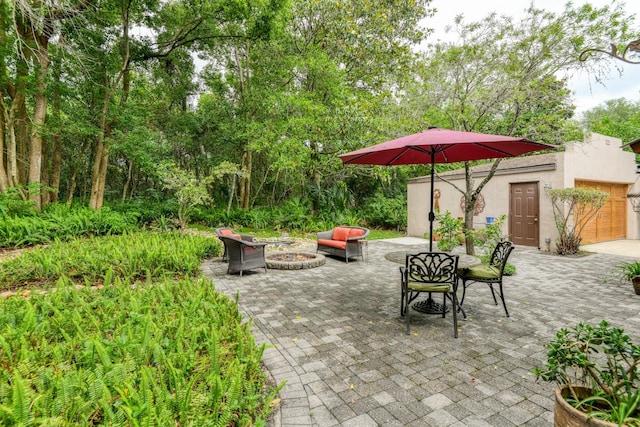 998 Aragon Ave, Saint Augustine, FL 32086 - view of patio / terrace featuring an outdoor fire pit, an outdoor structure, and outdoor dining area