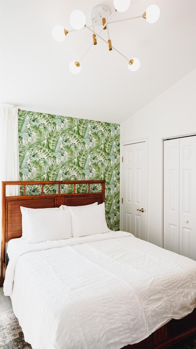 bedroom with vaulted ceiling, a closet, and wallpapered walls