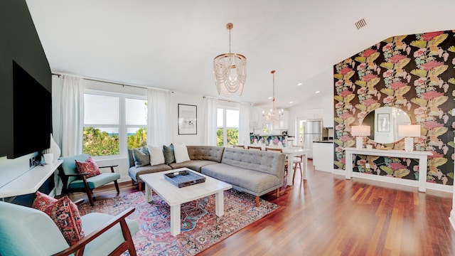 670 A1A Beach Blvd Unit D, Saint Augustine, FL 32080 - living room with a chandelier, light wood finished floors, baseboards, lofted ceiling, and wallpapered walls