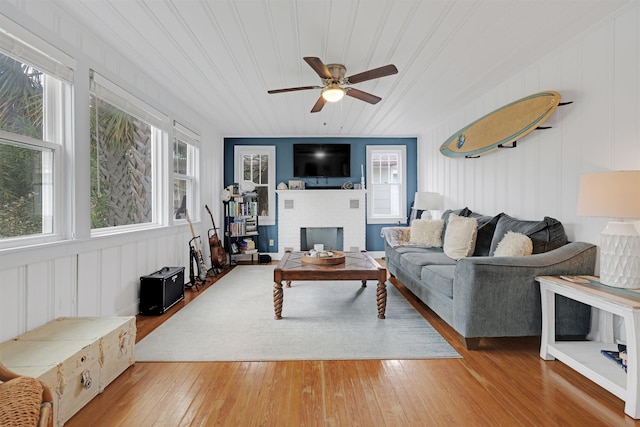 living room featuring hardwood / wood-style flooring, a brick fireplace, plenty of natural light, and wood ceiling