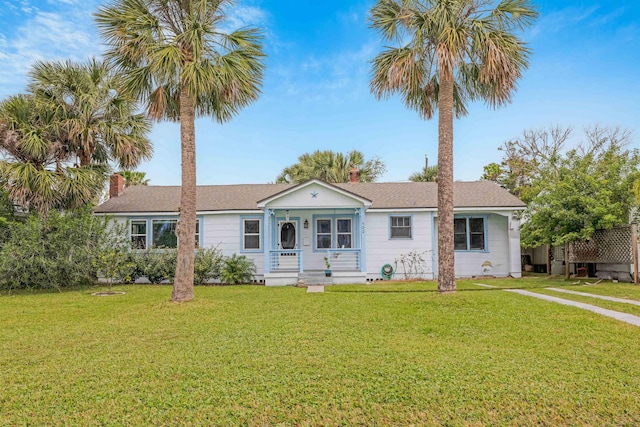 ranch-style home featuring covered porch and a front yard