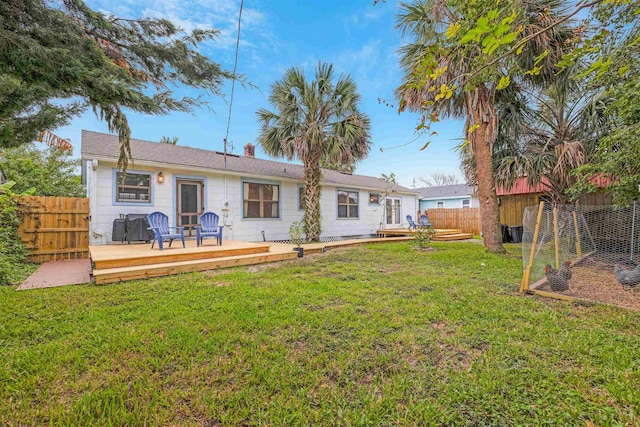 rear view of property with a deck and a lawn