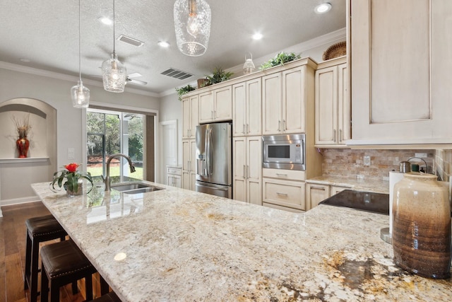 kitchen with backsplash, a textured ceiling, stainless steel appliances, sink, and hanging light fixtures