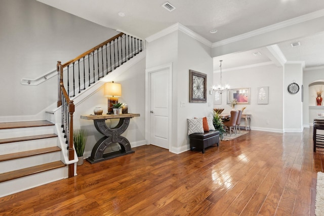 entryway featuring wood-type flooring, an inviting chandelier, and crown molding