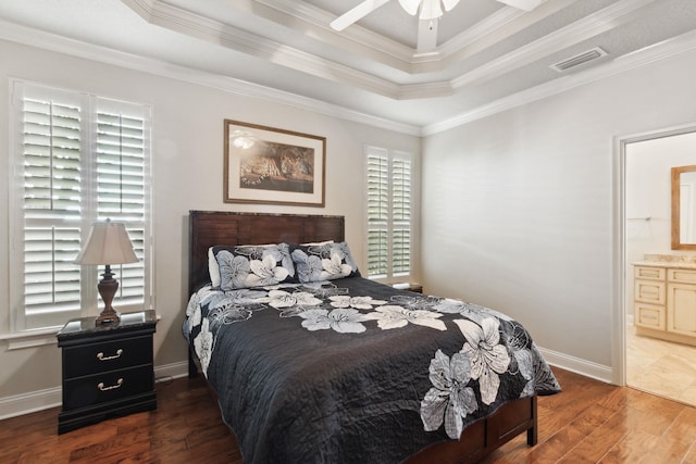 bedroom featuring dark hardwood / wood-style flooring, ensuite bathroom, crown molding, and ceiling fan