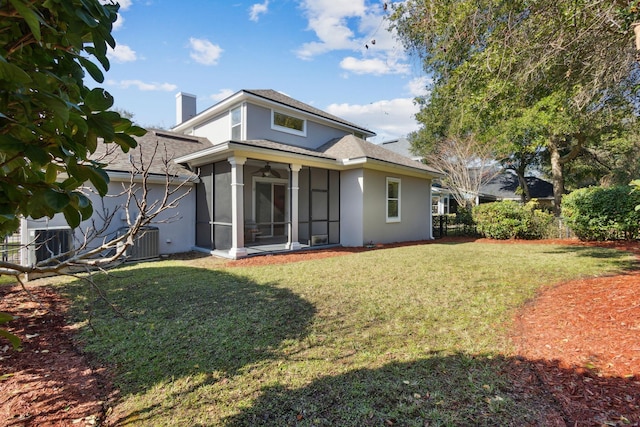 rear view of house featuring a yard, central AC, and a sunroom