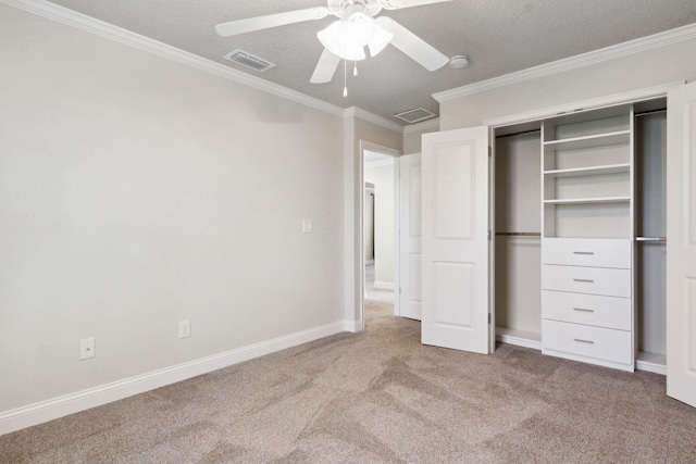 unfurnished bedroom featuring ceiling fan, carpet floors, a textured ceiling, a closet, and ornamental molding