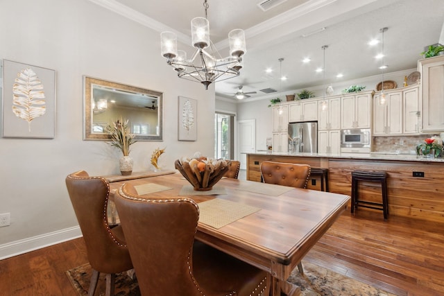 dining area with hardwood / wood-style floors, ceiling fan with notable chandelier, and ornamental molding