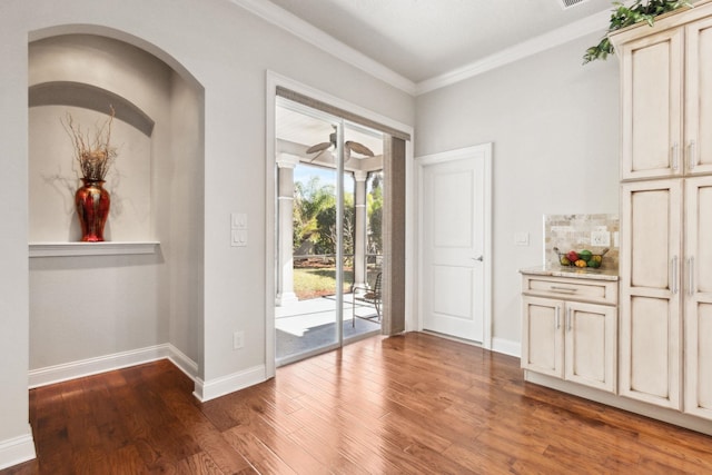 doorway with dark hardwood / wood-style flooring and ornamental molding