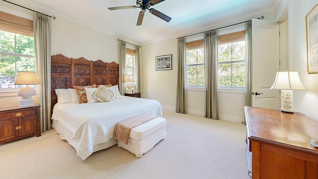 bedroom featuring ceiling fan, crown molding, baseboards, and light carpet