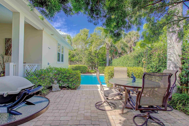 view of patio / terrace with outdoor dining space, a grill, and an outdoor pool