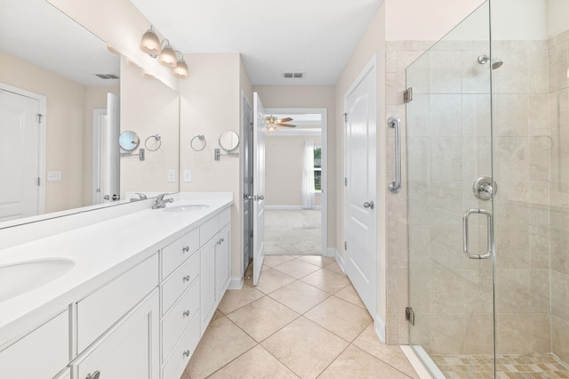 full bathroom featuring a shower stall, tile patterned flooring, double vanity, and baseboards